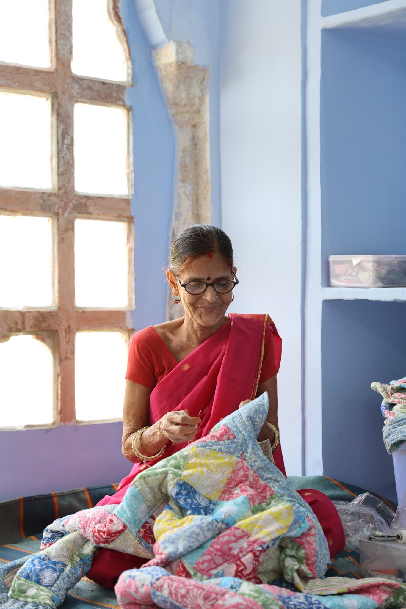 Artisan at PDKF Store sewing a block printed fabric