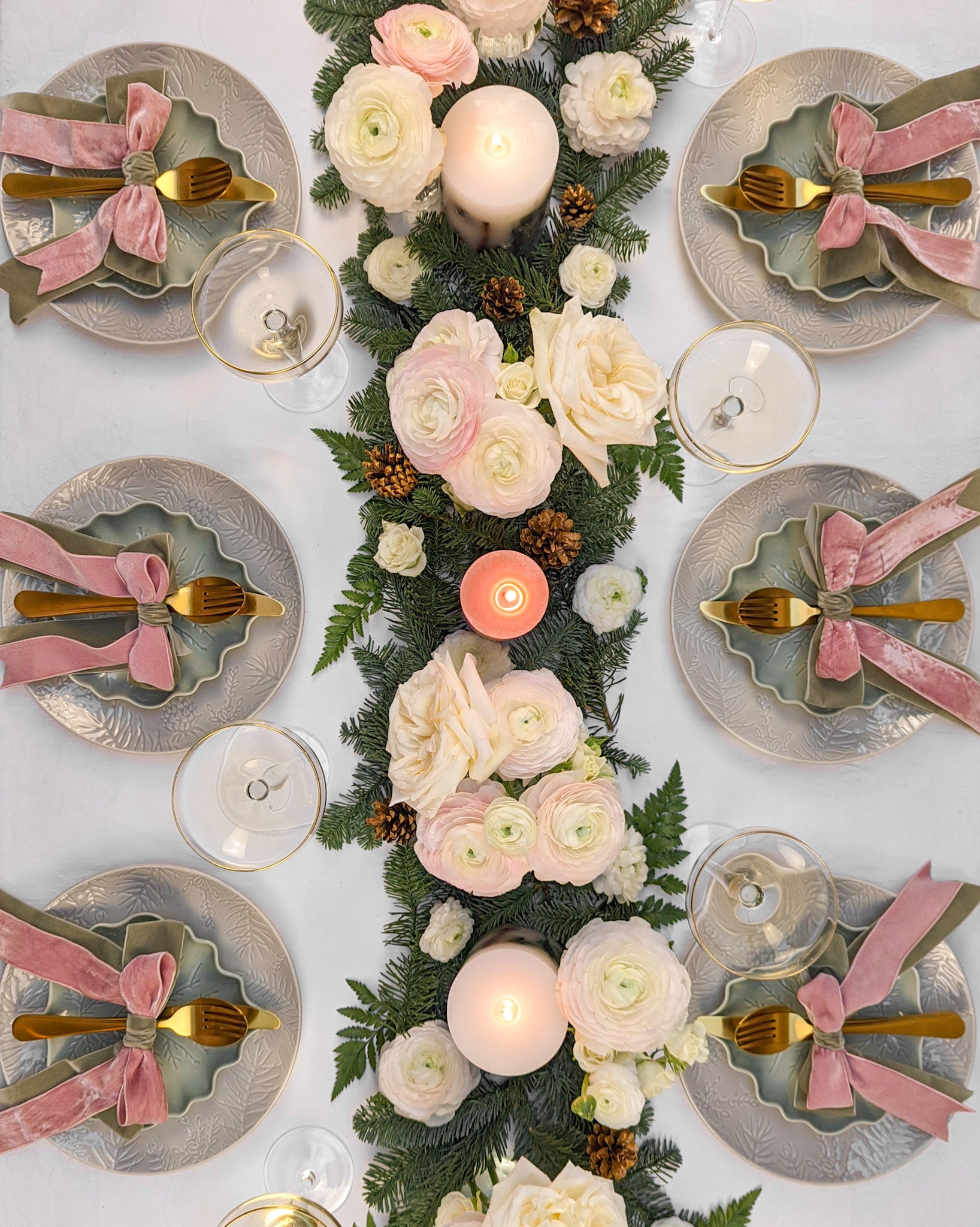 Pink and sage green tablescape with pine and spruce centrepiece and bows