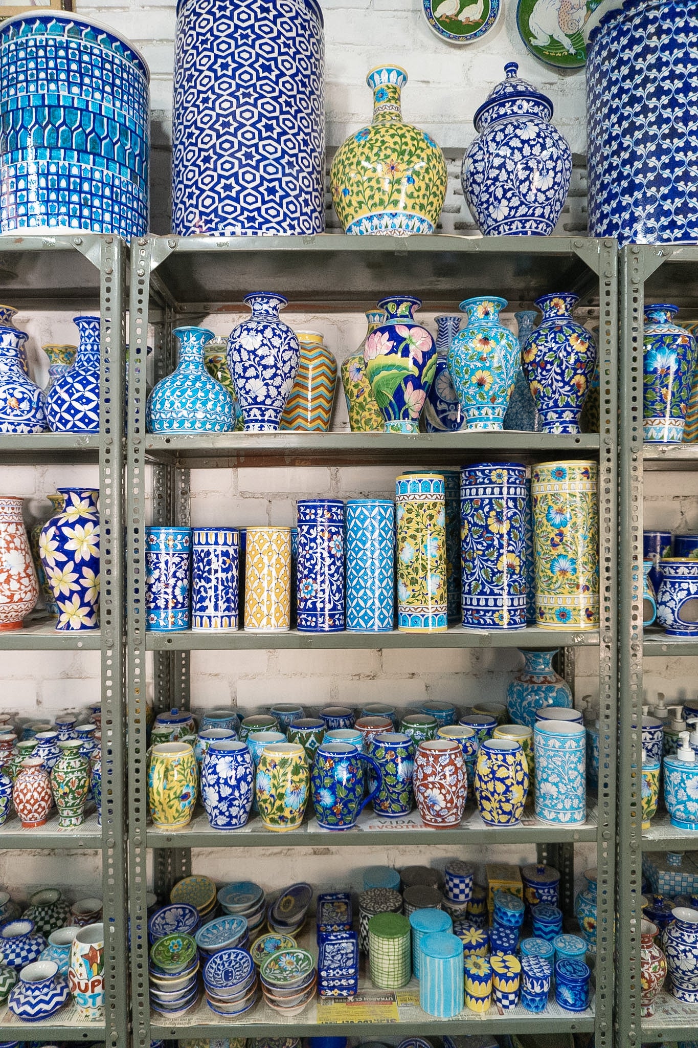 Shelves filled with various colorful ceramic vases and jars.