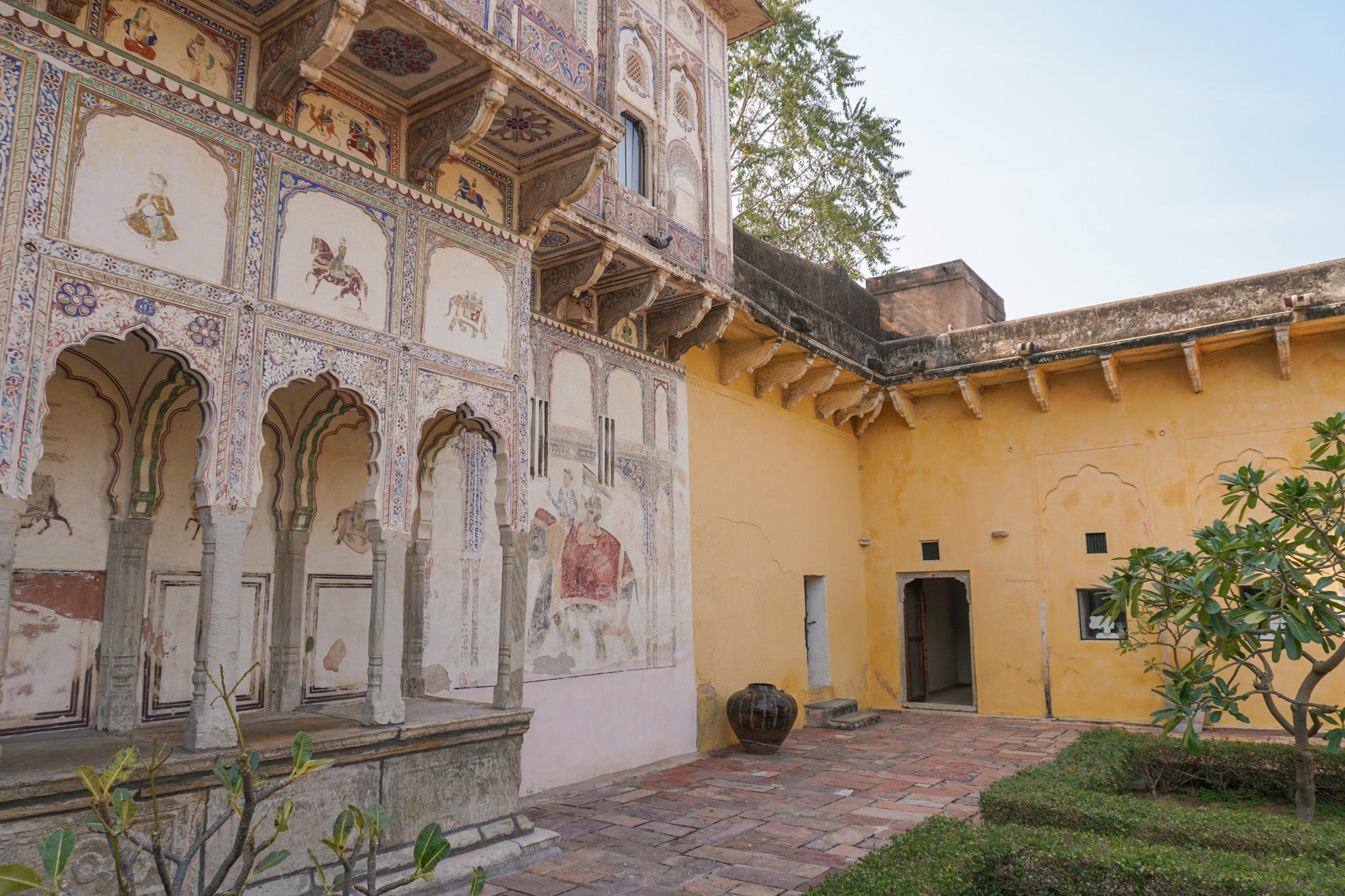 Deeppura Garh facade in India with yellow wall and painted frescoes