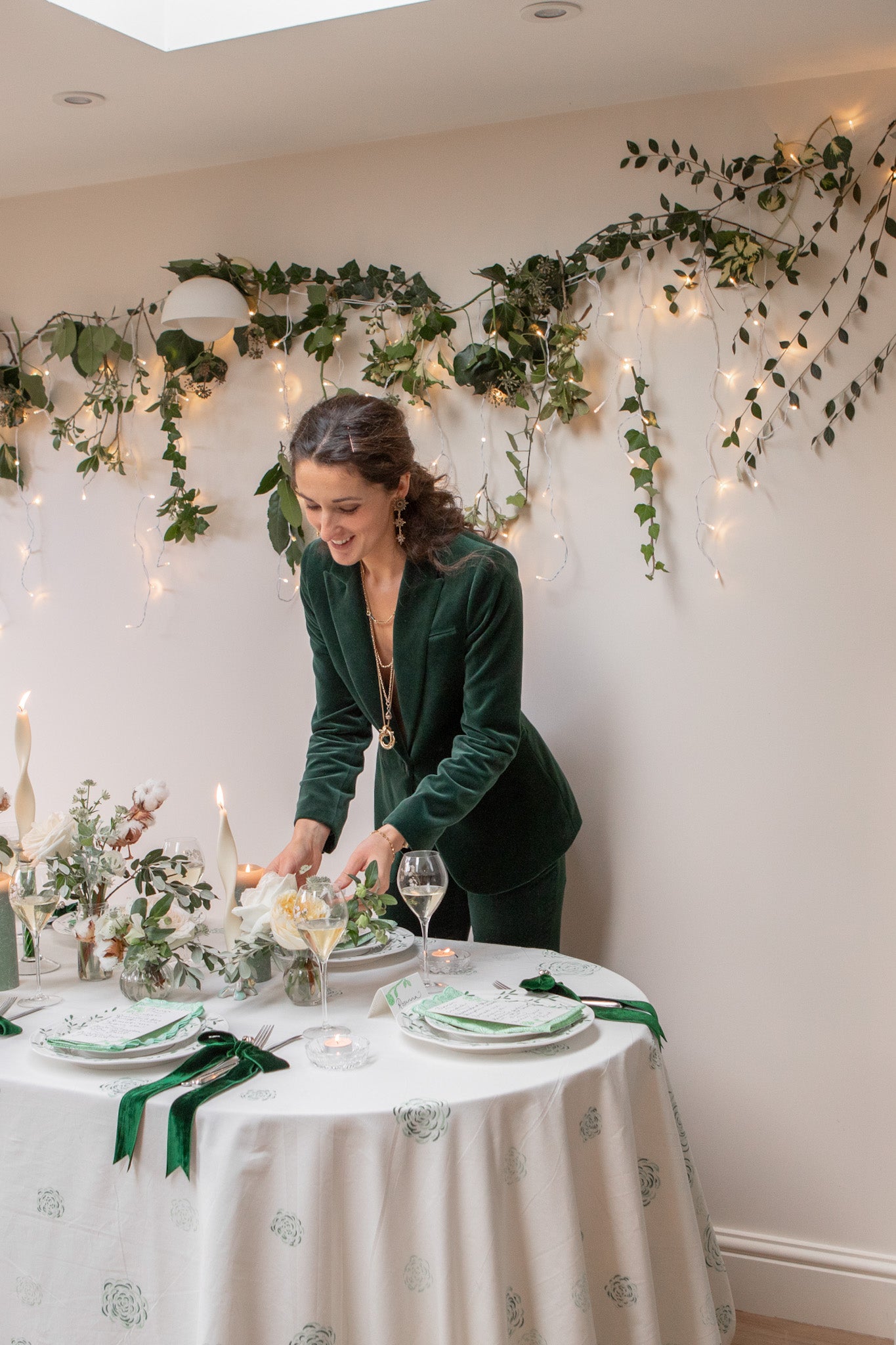 Green and white festive tablescape with foliage backdrop