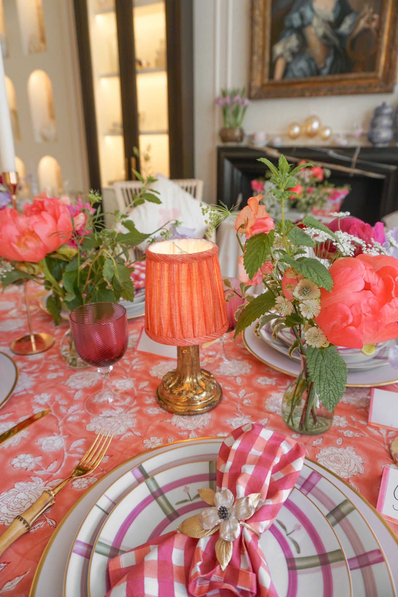 Lamp and lampshade next to peonies on table