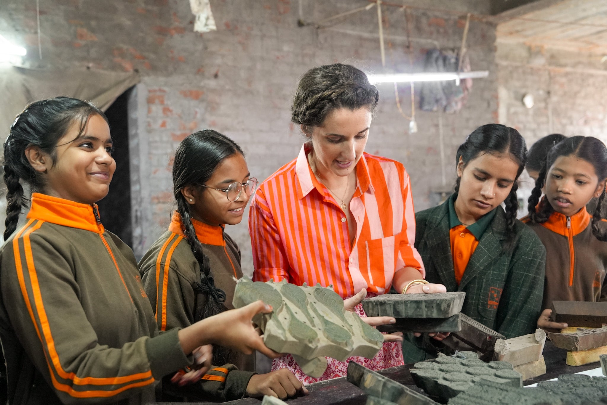 Group of children from Vimukti Sanstha and Rosanna Falconer in a block printing setting, working with materials.