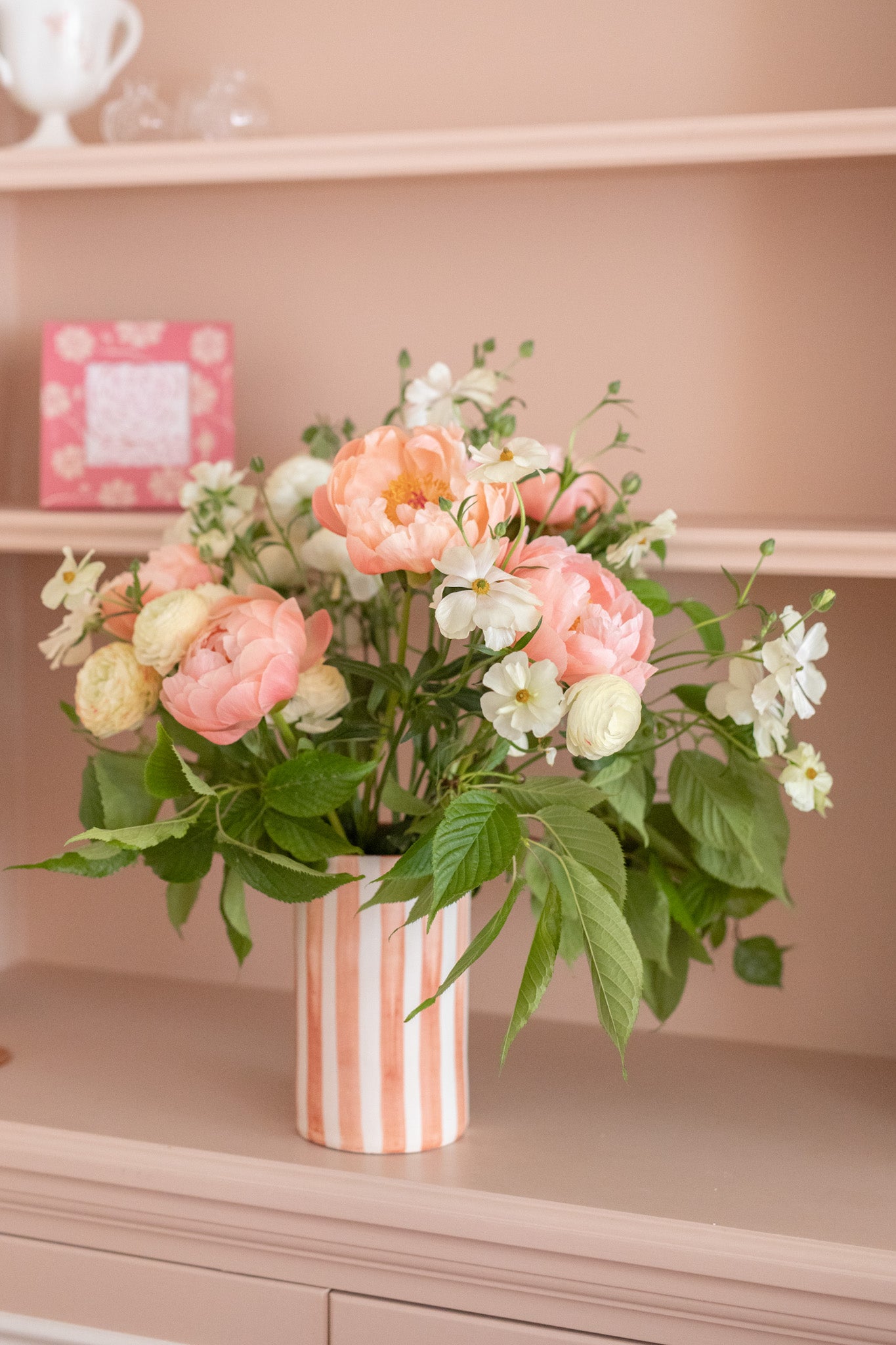 Striped terracotta and white vase with coral charm peonies