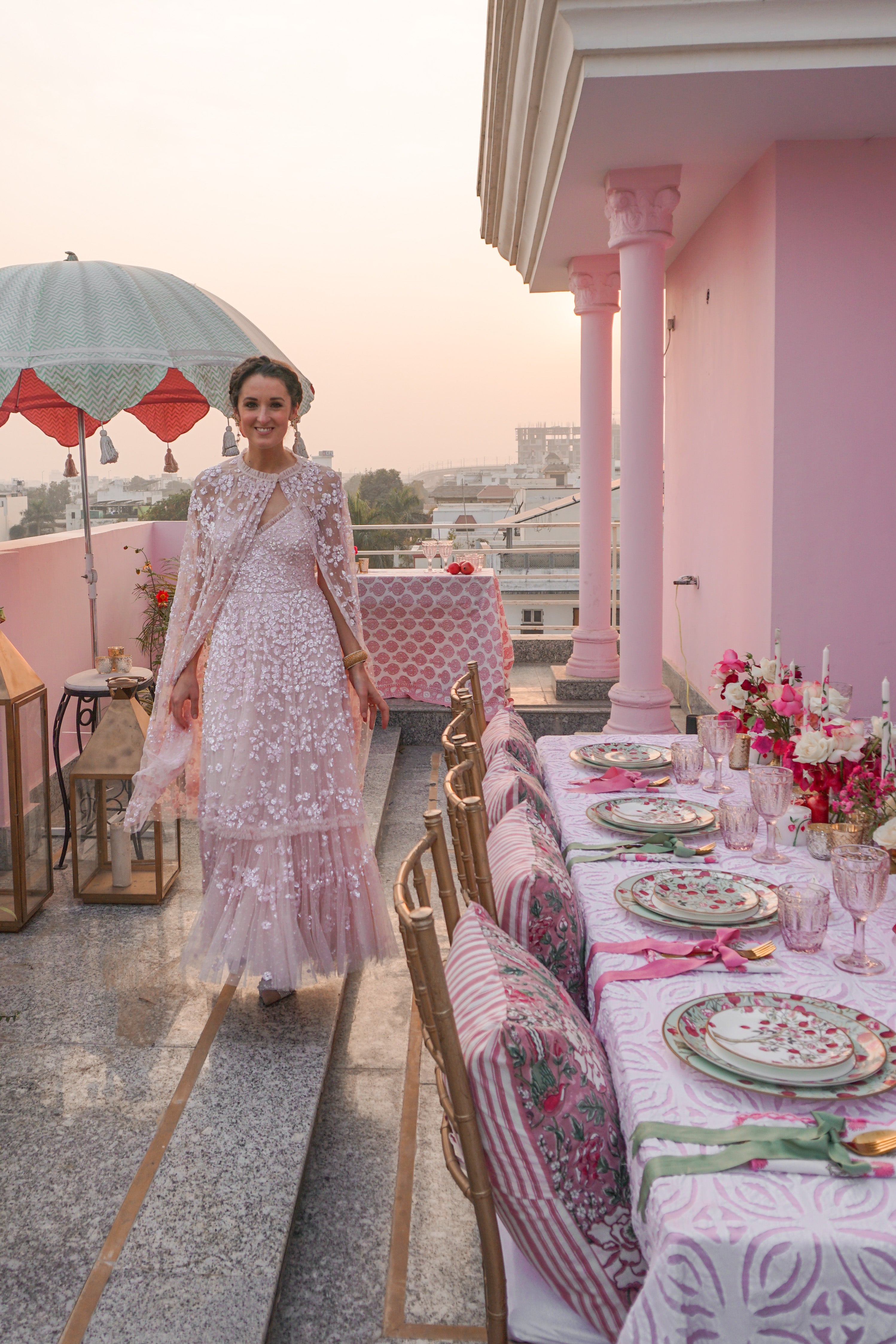 Rosanna Falconer wearing Needle & Thread pink dress and cape on terrace