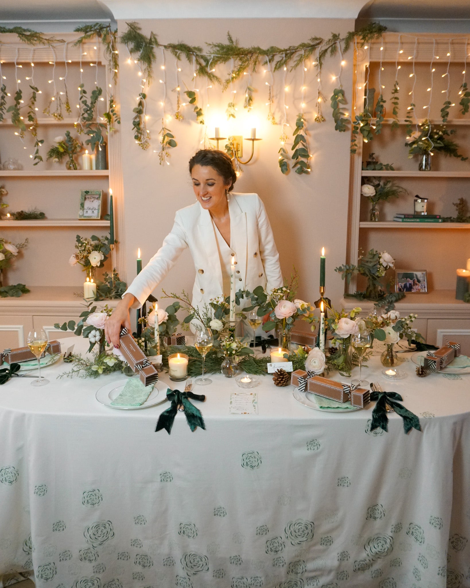 Rosanna in white suit putting cracker on winter festive tablescape